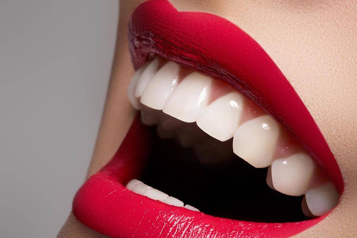 Smiling face with white teeth and red lipstick